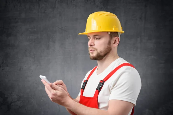 Travailleur de la construction utilisant un smartphone — Photo