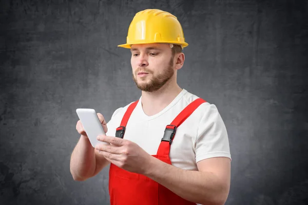 Travailleur de la construction utilisant un smartphone — Photo