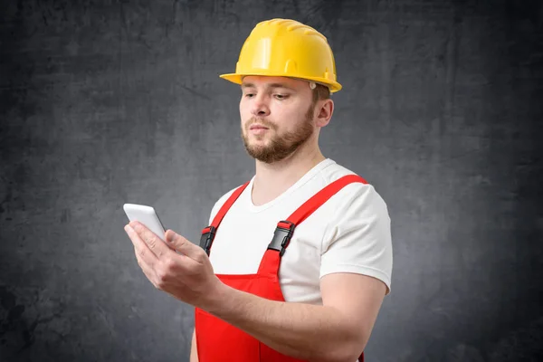 Travailleur de la construction utilisant un smartphone — Photo