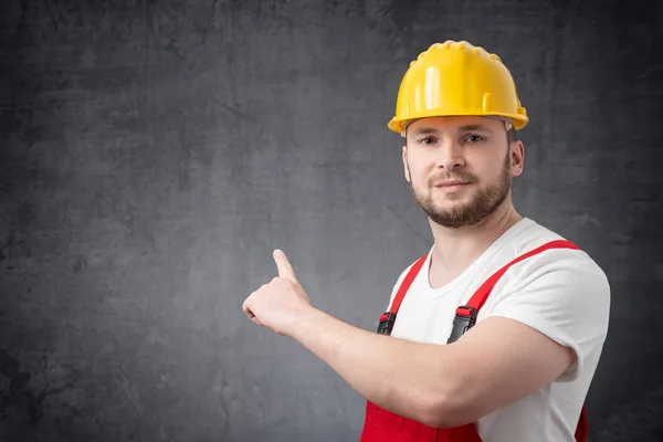 Arbeidstaker som peker på veggen – stockfoto