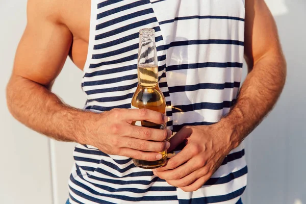 Nahaufnahme von männlichen Händen mit einer Flasche Bier im Freien — Stockfoto