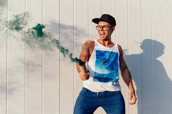 Chico alegre sostiene una bengala de humo de pie al aire libre . — Foto de Stock