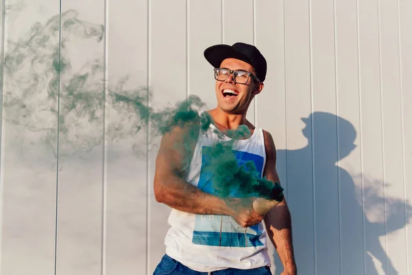 Chico alegre agitando una bomba de humo, al aire libre — Foto de Stock