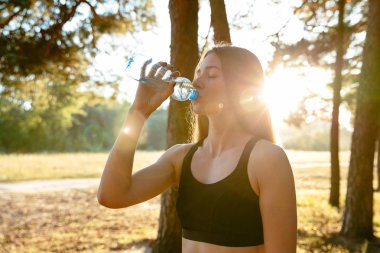Parkta egzersiz sonra su içme güzel kız