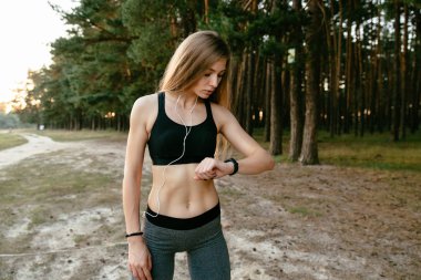 Güzel kız açık havada çalıştırdıktan sonra zaman kontrol