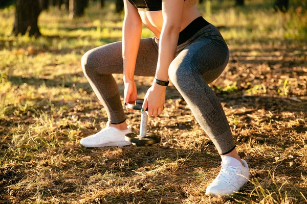 Fitness femenina levantamiento de pesas durante el entrenamiento al aire libre — Foto de Stock