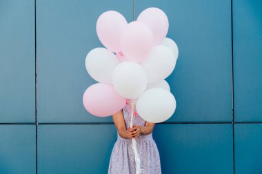 Yüzünü bir sürü balonla saklayan kadın, dışarıda