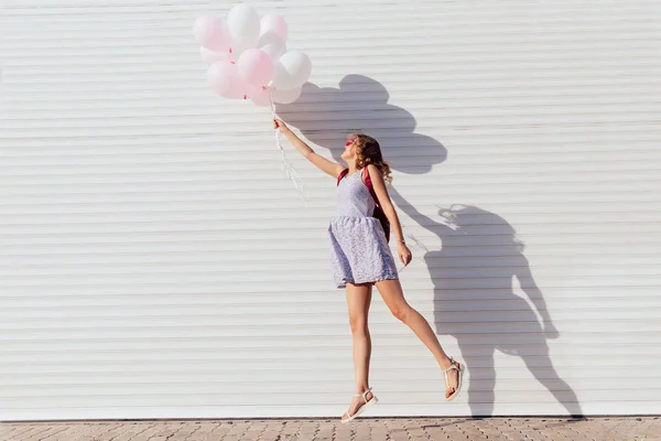 Vista lateral de la chica saltando con globos de aire, al aire libre — Foto de Stock
