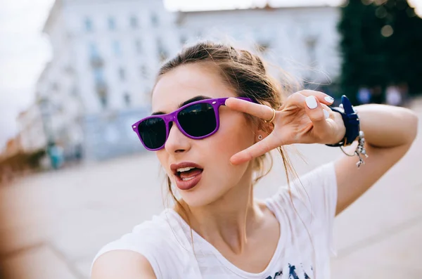 Chica encantadora mostrando una señal de paz, mientras pasea al aire libre — Foto de Stock