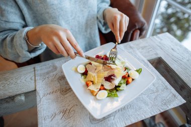 Kadın bir restoranda lezzetli bir Sezar salatası yiyor. Portre