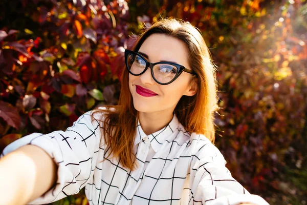 A gyönyörű lány szemüvegét őszi selfie portréja. — Stock Fotó