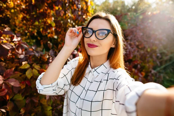 A gyönyörű lány szemüvegét őszi selfie portréja. — Stock Fotó