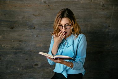 Güzel kadın bir kitap okurken bir şey hakkında şok