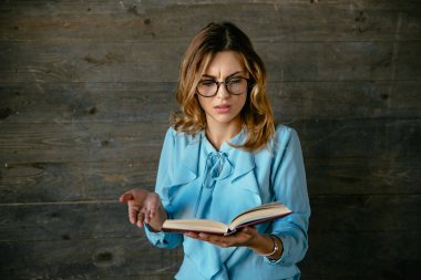 Bir kitap okurken karışık yüzü ile Charming iş kadını