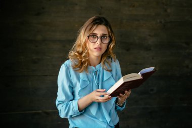 Çekici kadın bir kitap okurken üzgün görünüyor