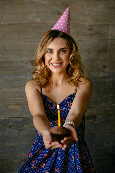 Atrakcyjna dziewczyna trzyma czekoladę Cupcake ze świecą — Zdjęcie stockowe