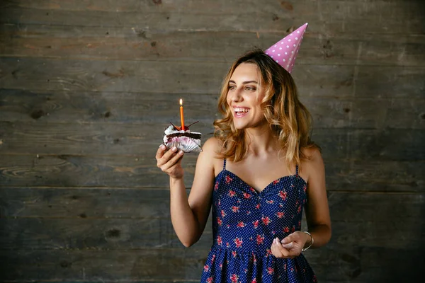 Happy Woman patrząc na kawałek ciasto czekoladowe ze świecą — Zdjęcie stockowe