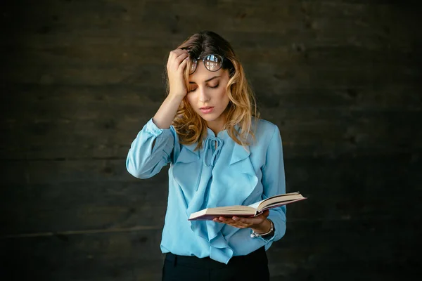 Müde Frau mit Buch in der Hand — Stockfoto