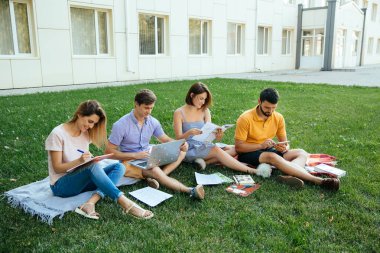 Not ile rahat kıyafetler içinde neşeli öğrenciler genç grup