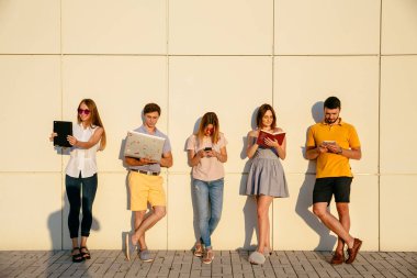 Güzel genç öğrenciler gadget'lar kullanıyor, kitap okuma ve smi
