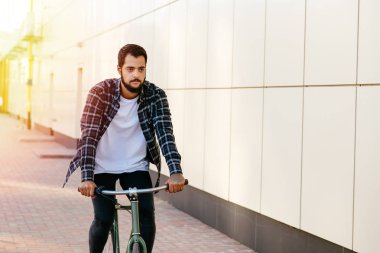 Şehir caddesinde bisiklete binen pensive çekici adam