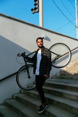 Metroda merdivenlerde bisikletle inen çekici adam