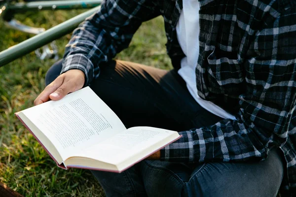 Hombre leyendo interesante libro mientras está sentado en la hierba — Foto de Stock