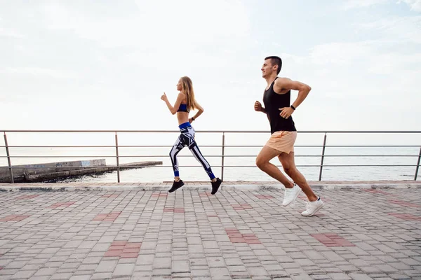 Fitness man and woman running outdoors — Stock Photo, Image