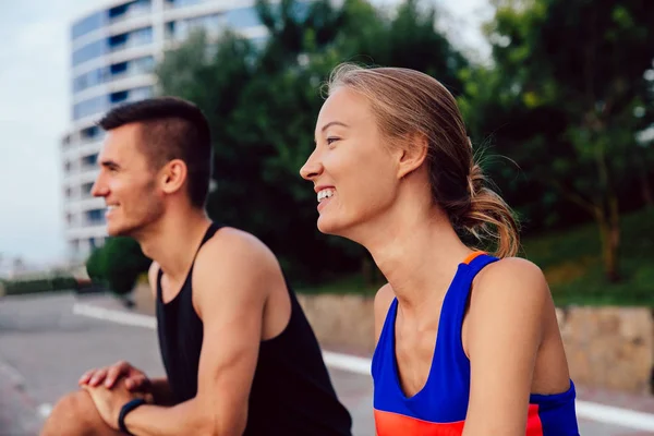 Sonriente chica con el hombre haciendo ejercicio al aire libre — Foto de Stock