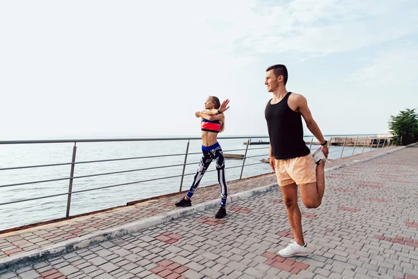 Guy y chica entrenando juntos cerca del mar . — Foto de Stock