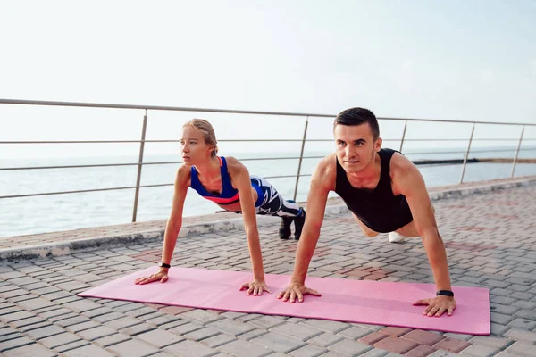 Joven deportista y deportista haciendo tablón al aire libre — Foto de Stock