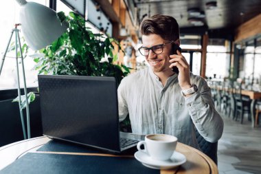 Neşeli işadamı dinlenirken telefon görüşmesi yapıyor 