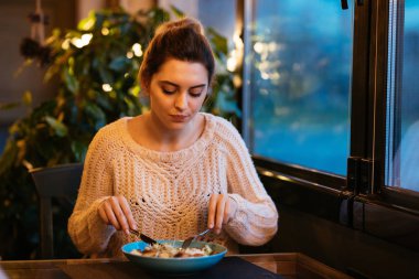 Kafede otururken taze salata yiyen güzel kadın