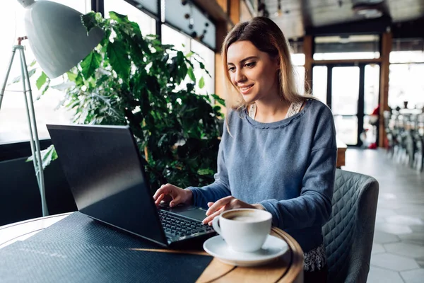 Mosolygó nő ül a kávézóban, laptop — Stock Fotó