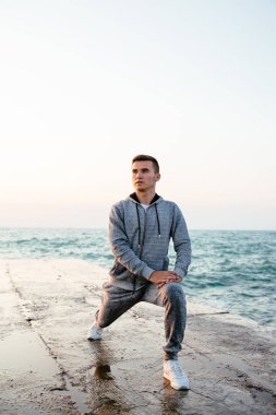 Bacaklar için egzersiz yapan yakışıklı adamın tam uzunlukta fotoğraf, rıhtım