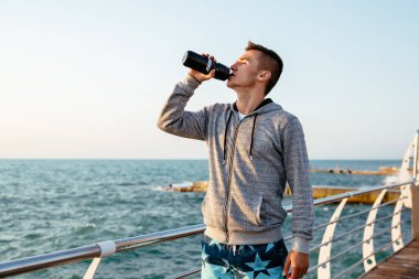 Çekici sporcu açık havada egzersiz sonrası bir su içme