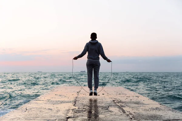 Deportista saltando con la cuerda de saltar, entrenamiento en el muelle — Foto de Stock