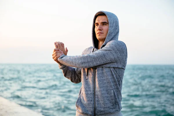 Deportista concentrado haciendo ejercicio para el brazo, al aire libre — Foto de Stock