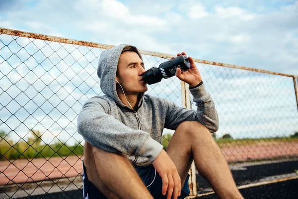 Oturan sporcu su içiyor