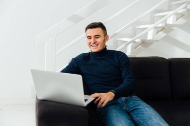 Mutlu adam evde, dizüstü ekran bakarak