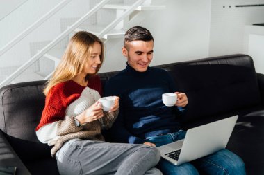 İki en iyi arkadaş evde, çay içerken dizüstü ekran bakarak.