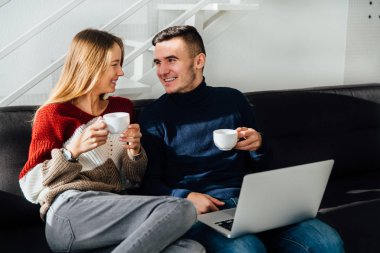 Güzel çift görünümlü ve bir çay içerken birbirlerine gülümseyen