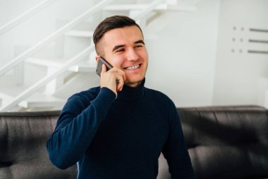 Mutlu adam evde cep telefonu konuşuyor