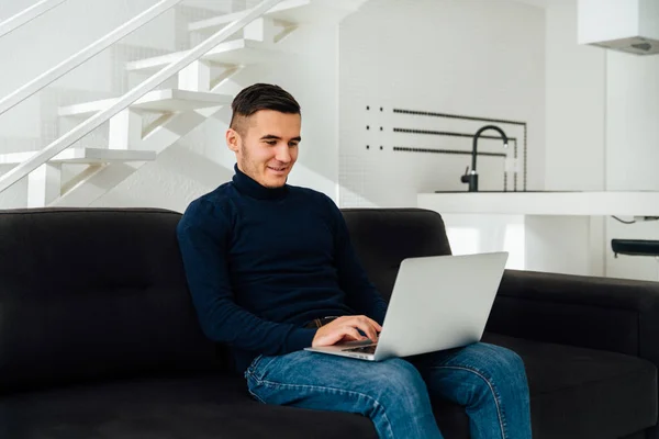 Uśmiechnięty człowiek pracujący z laptopem, w domu — Zdjęcie stockowe