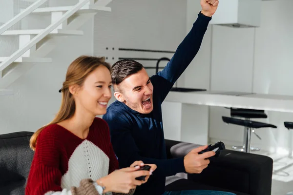 Chico feliz mostrando gesto ganador después de jugar juegos de ordenador con la novia —  Fotos de Stock
