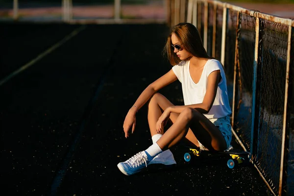 Sexy Woman Looks Downstairs While Sitting Her Skateboard — Stock Photo, Image