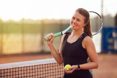 Tenis ağına yakın raket ve top ile neşeli sporcu