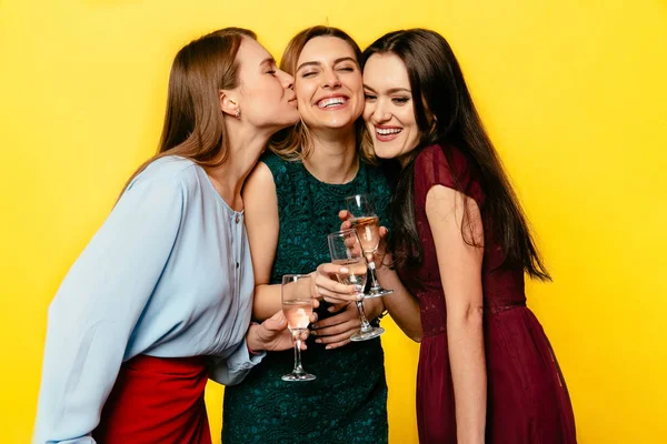 Tre vackra flickor som innehar vinglas med champagne, fira en semester Stockfoto