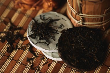 Geleneksel Çince puer çay bir bambu hasır üzerinde. Yakın çekim. Yumuşak seçici odak.