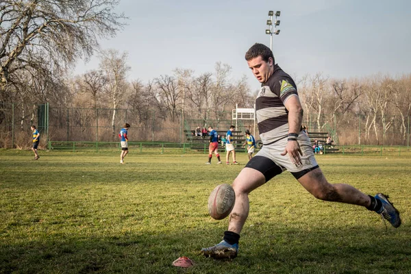 BELGRADE, SERBIA - MARCH 1, 2015:  Young man shooting at a rugby ball doing  Drop Goal  during a Partizan Rugby team training